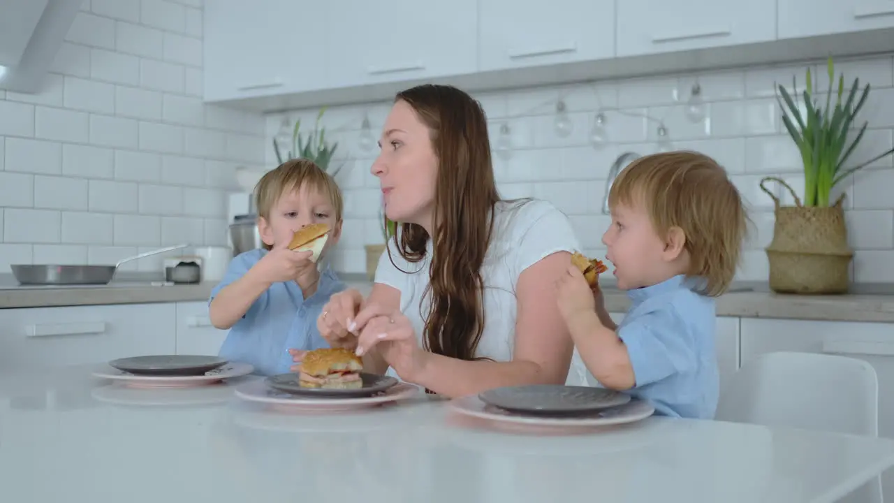 Children in the kitchen feed their mom with self-cooked diet burgers