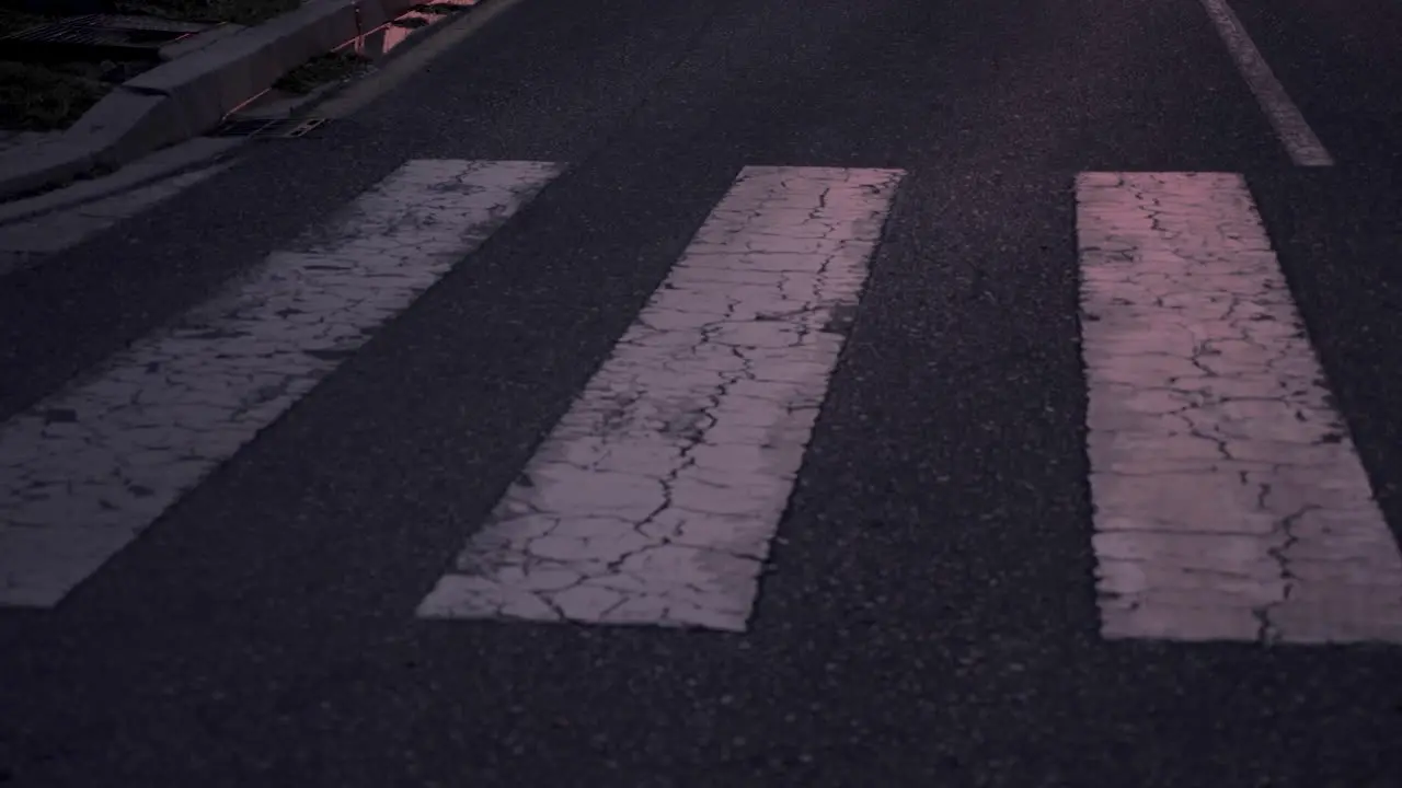 Close Up Of Athlete Crossing A Crosswalk And Running In The City At Dusk