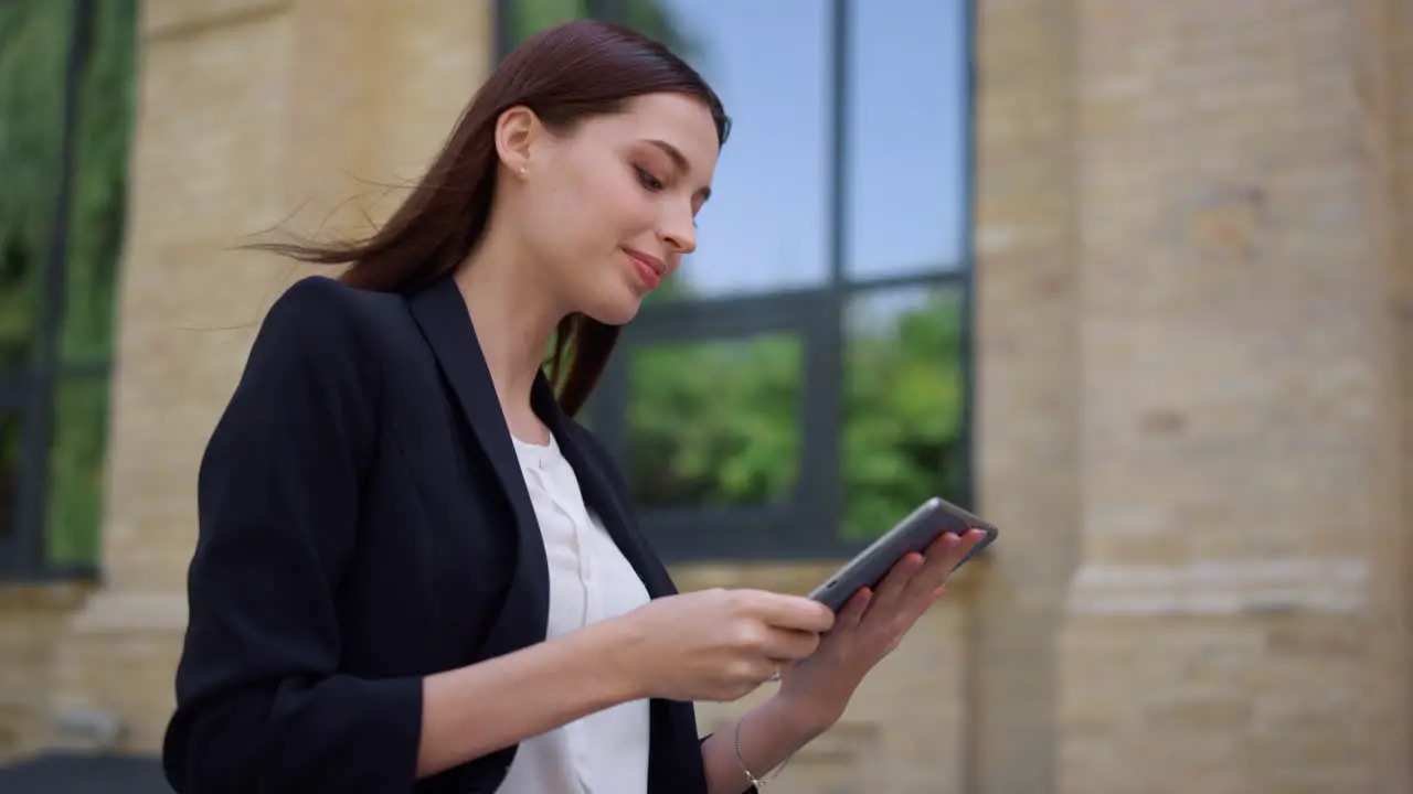 Business lady using tablet outdoors Smiling woman greeting colleague on street