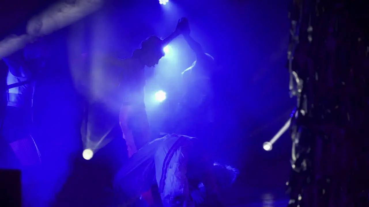 A group of dancers performing in front of a crowd in a club