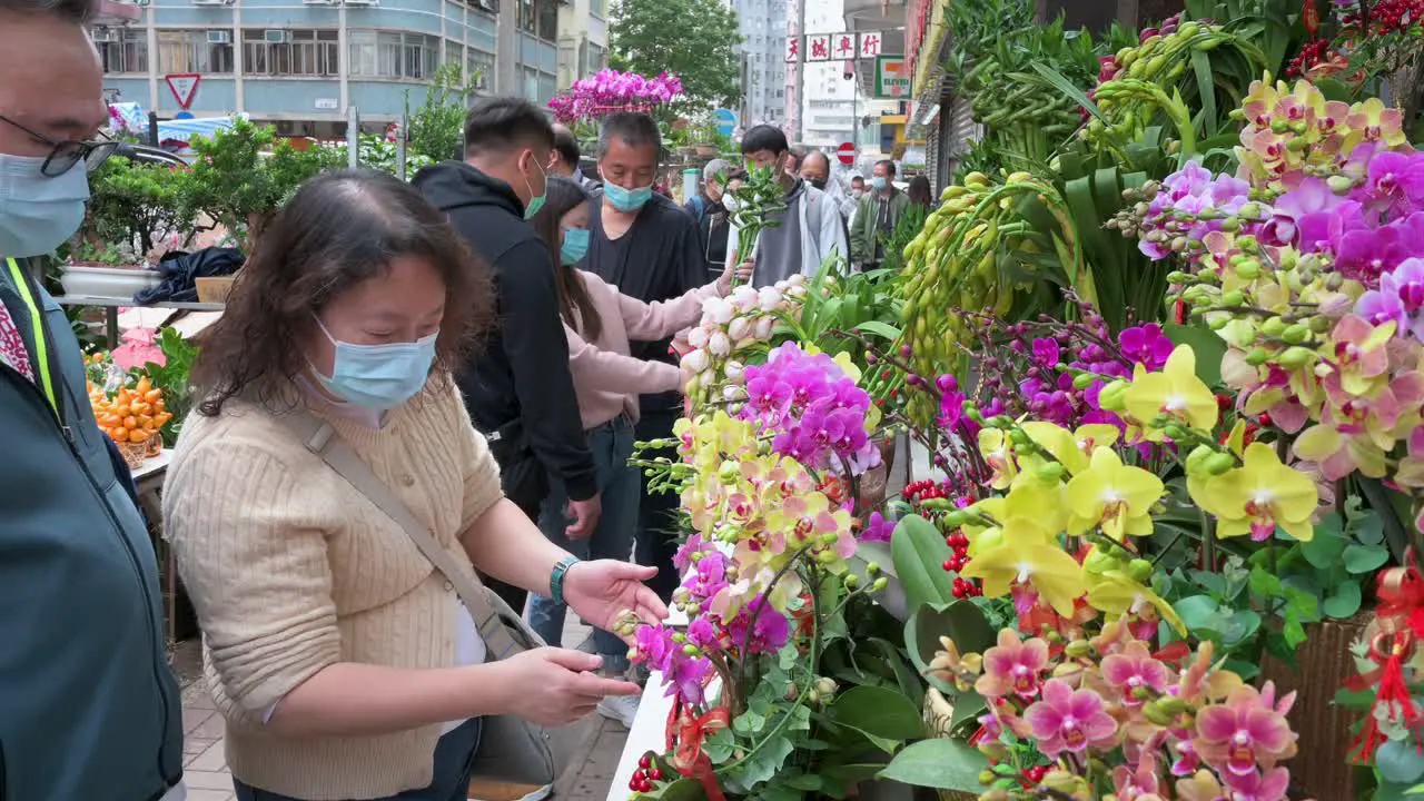 People buy decorative Chinese New Year theme flowers and plants at a flower market street stall ahead of the Lunar Chinese New Year festivities