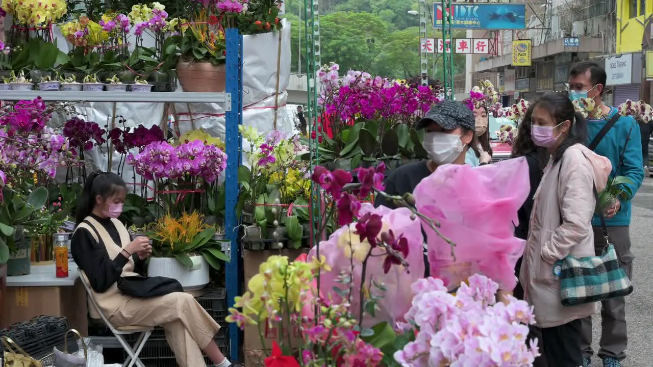 Chinese shoppers buy decorative Chinese New Year flowers and plants at a flower market street stall ahead of the Lunar Chinese New Year festivities