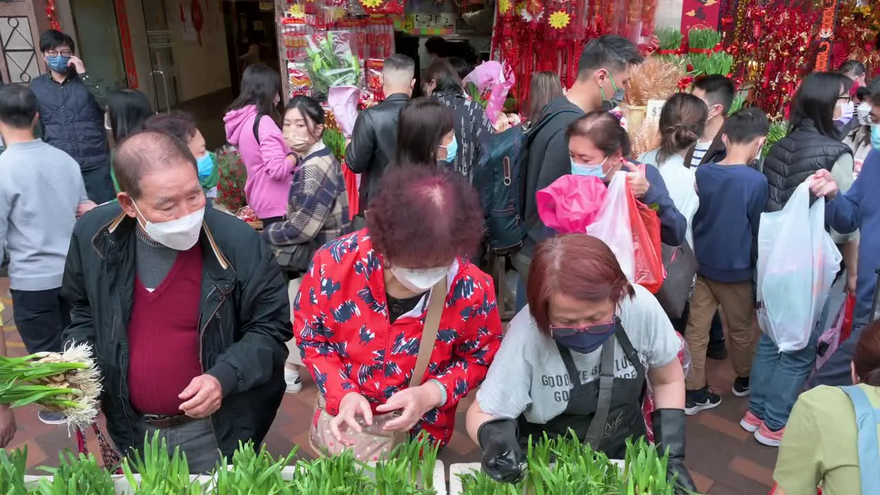 Chinese shoppers buy decorative Chinese New Year theme flowers and plants at a flower market street stall ahead of the Lunar Chinese New Year festivities