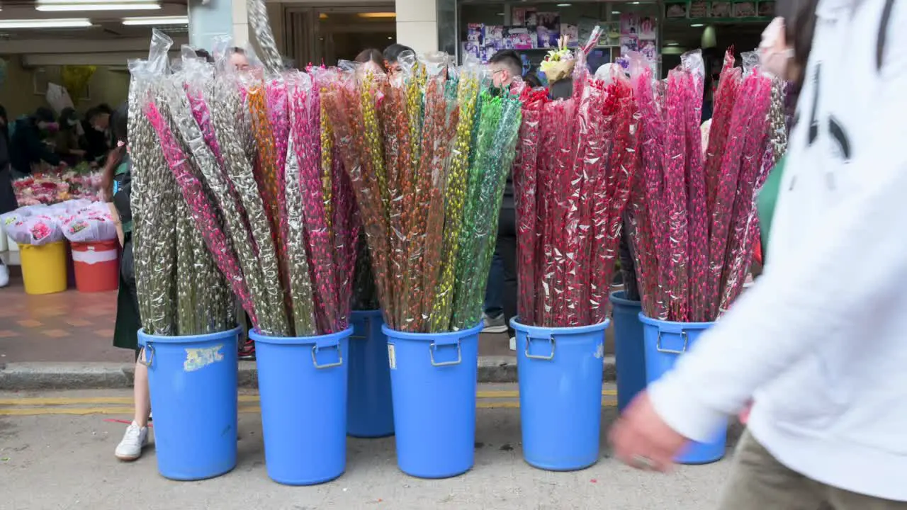 A flower stall offering and selling typical Chinese New Year themed flowers as people walk past it during preparations for the upcoming Lunar Chinese New Year at a flower market in Hong Kong