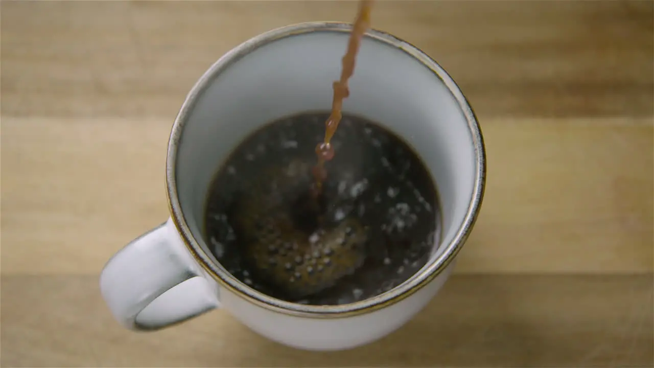 150fps SLOW MOTION WIDE black coffee pours into a cup splashing