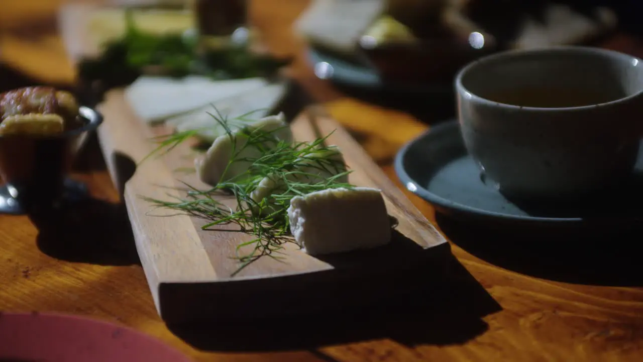 Close up shot of cheese selection board on table at bright restaurant