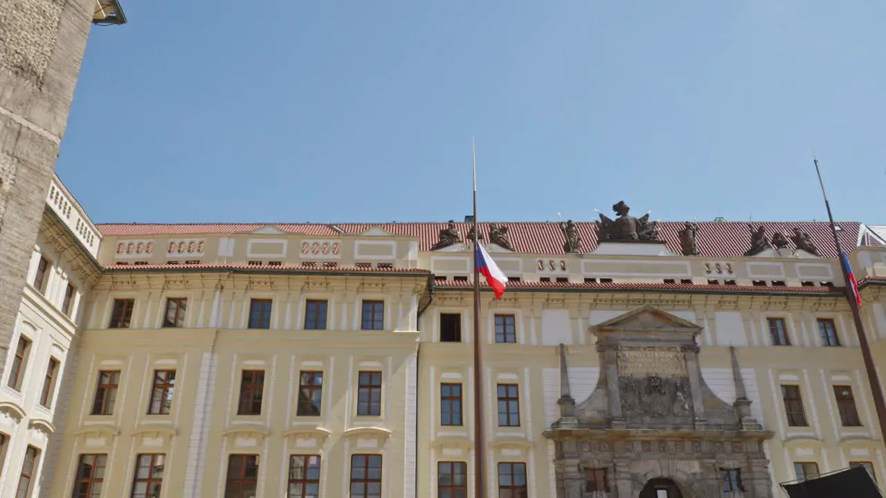 the Czech flag waving in slow motion with the monumental Royal Castle in Prague in background