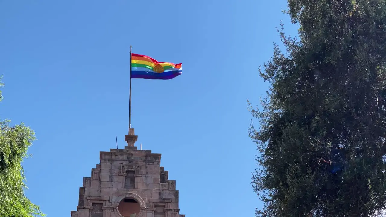 Inka Rainbow flag of Cusco Peru blows in the wind on a blue sky day