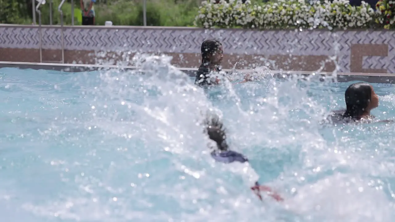 Asian Kids Splashing in Swimming Pool