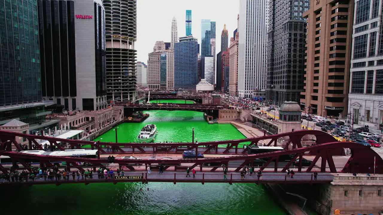 long bus on bridge and boat sailing under bridge during Saint Patricks day in chicago