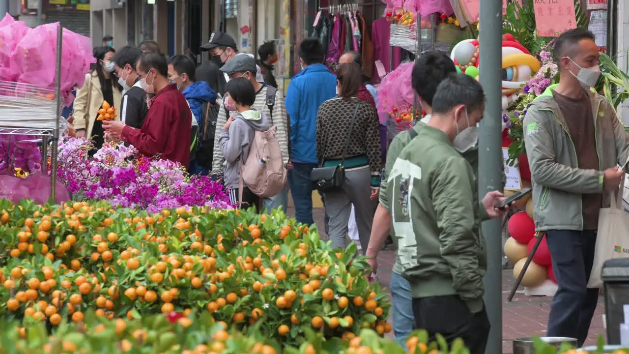 Chinese customers buy typical decorative Chinese New Year themed flowers and kumquat trees also known as tangerine trees at a flower market ahead of the Lunar Chinese New Year festivities