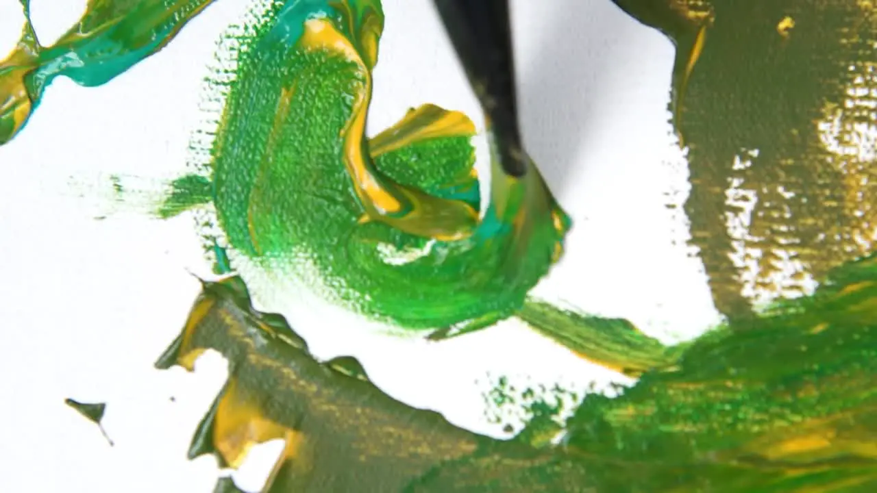 Close up brush painting artwork with green and yellow paint on white background