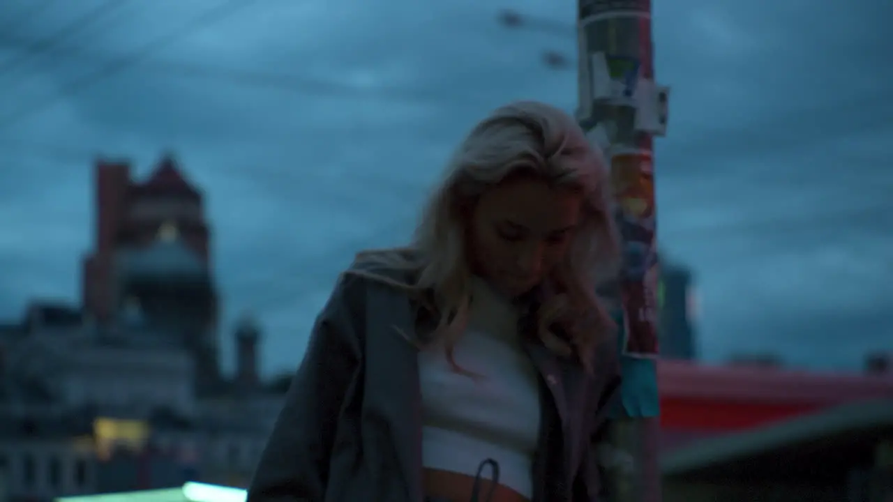 Girl in evening city standing near urban landscape street lights