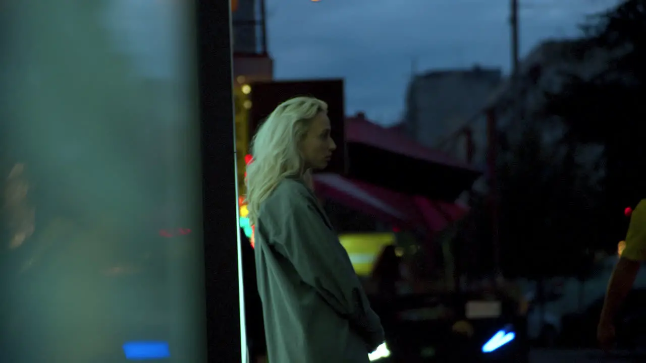 Blonde girl waiting city wearing casual clothes in evening urban area