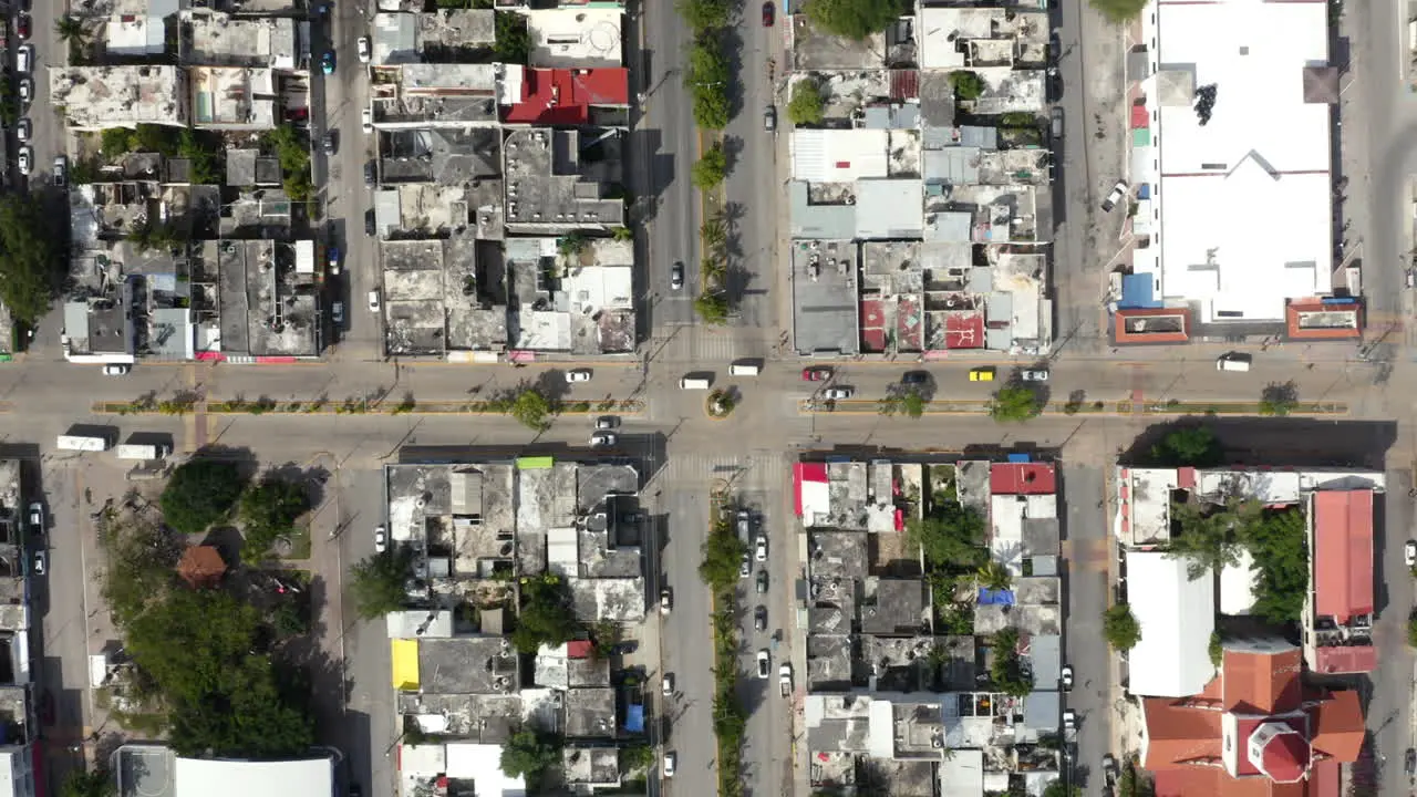 Cars driving on street crossroad between city house blocks in Mexico