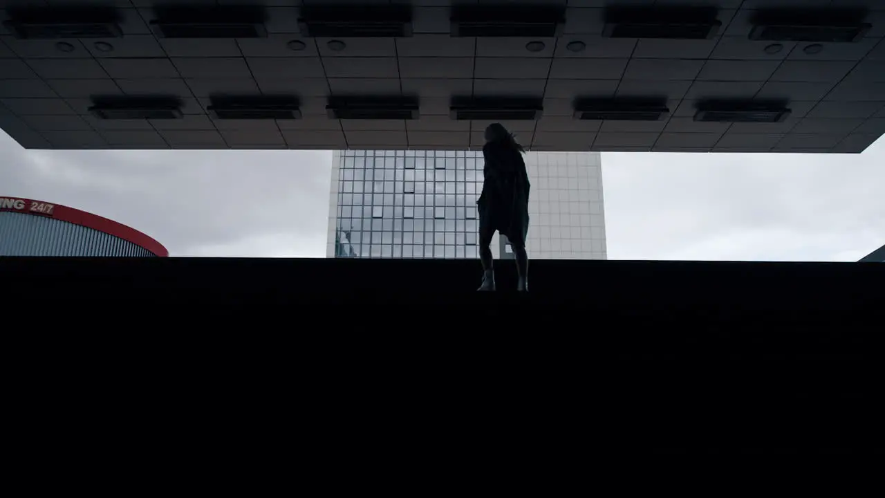 Silhouette girl walking stairs in dark underground station metro in city