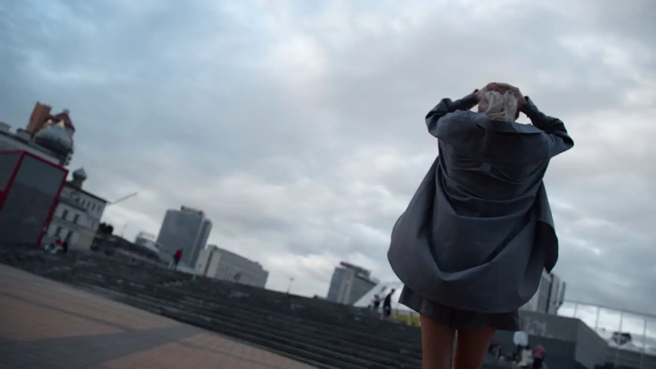 Woman walking big city wearing casual clothes in rainy weather downtown dusk