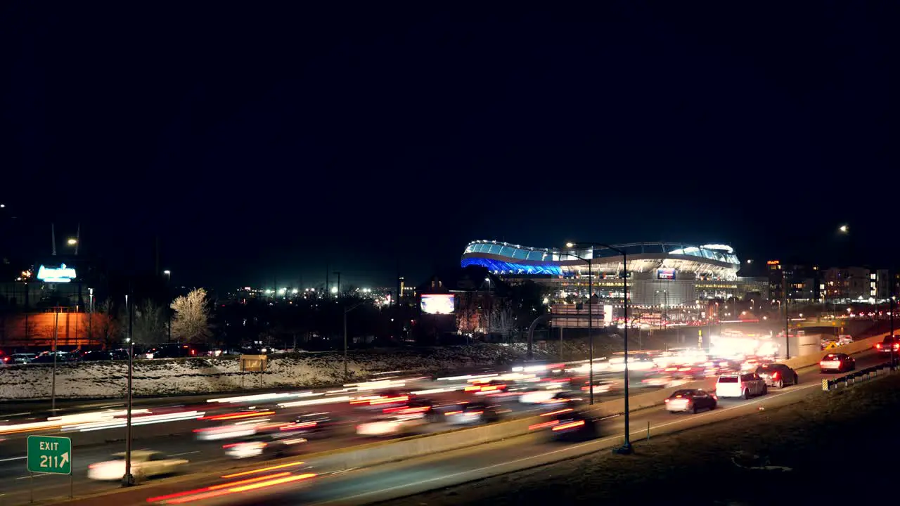 Time lapse of traffic flow on the Interstate against a background of the Mile High Stadium of Denver Broncos