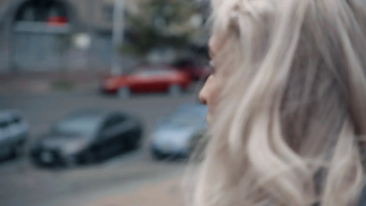 Blonde female person looking at city architecture in urban area