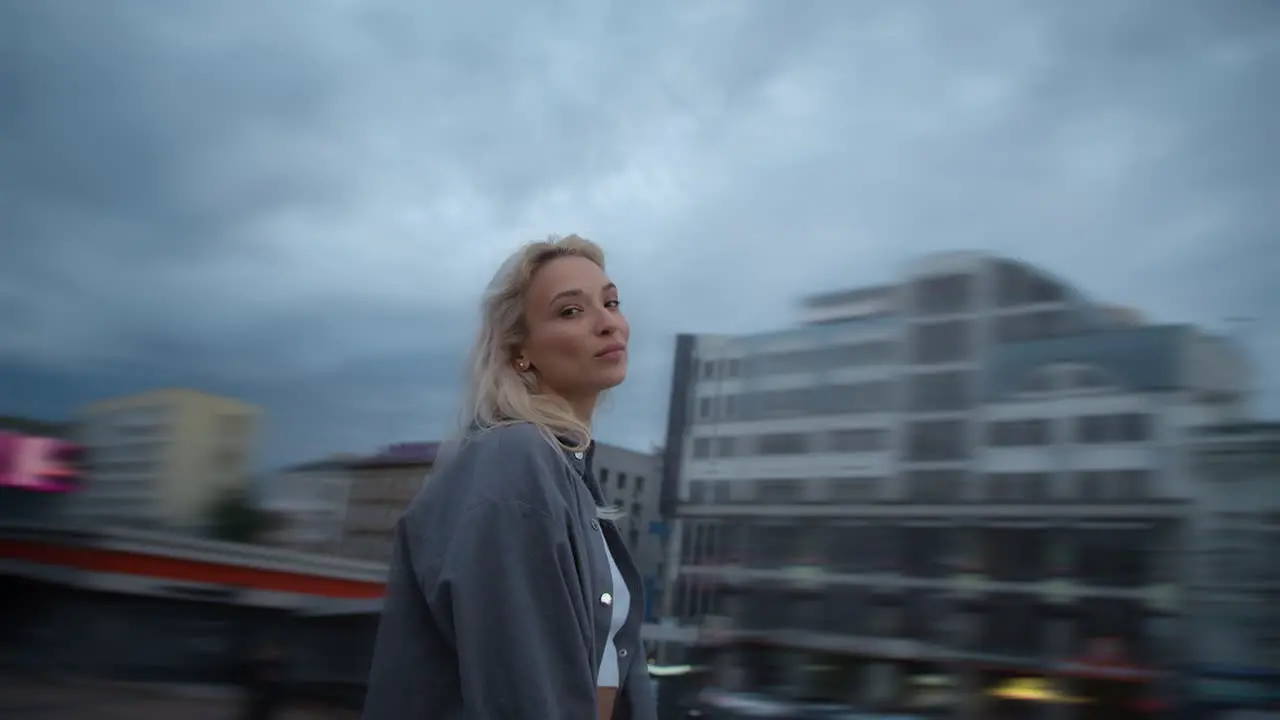 Smiling woman urban background looking camera in evening city