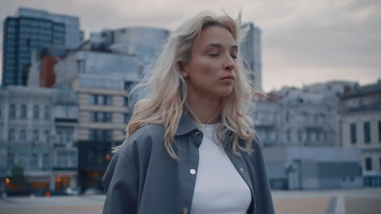 Blonde girl exploring city at dusk with urban background street lights