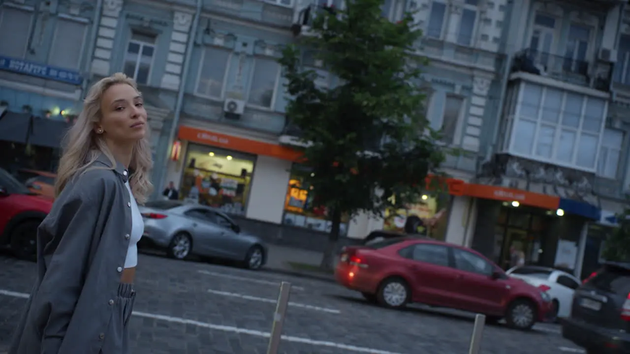 Happy woman walking city at late evening on urban background