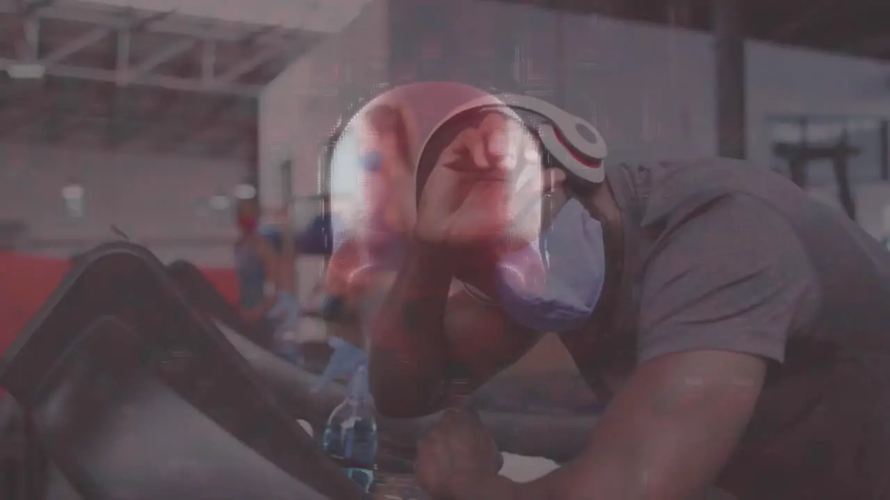 Human skull spinning against man wearing face mask working out at the gym