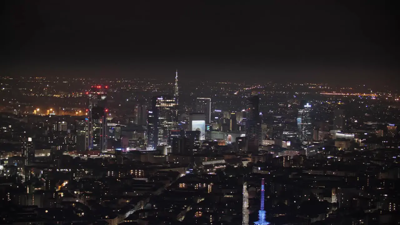 Porta Nuova of Milan at night with glowing lights aerial view