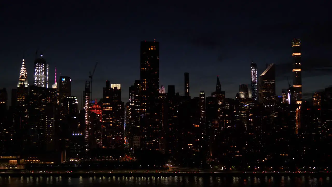 Establishing shot of East Side Manhattan New York City at dusk with the traffic on FDR Drive at the shore of East River Chrysler building and other skyscrapers filmed from Long Island City