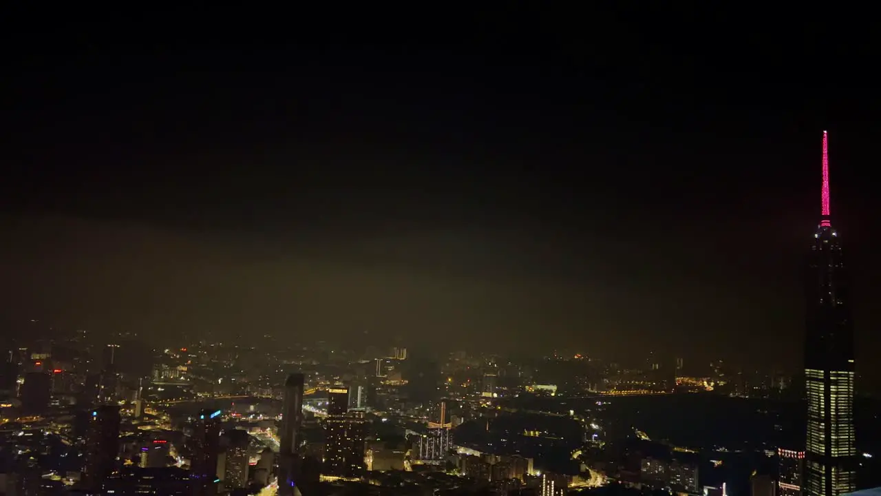 An aerial view of the city with skyscrapers and other building fully lit