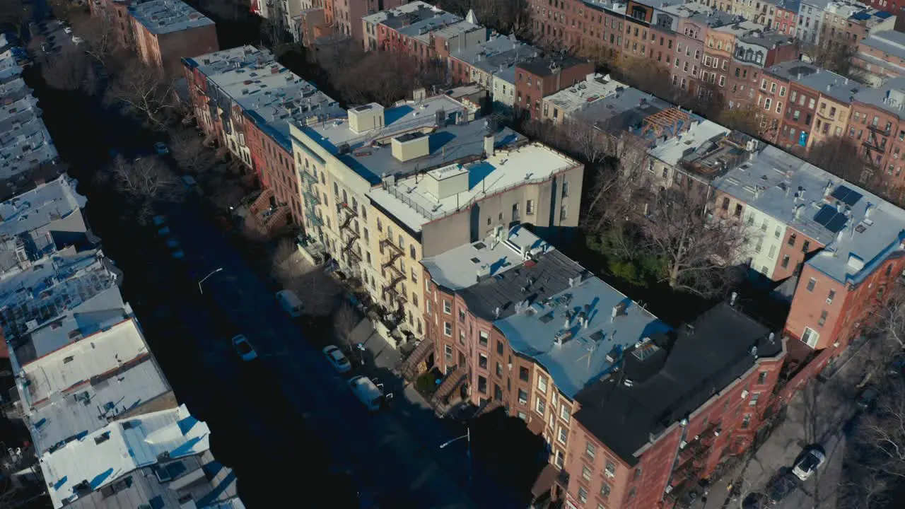 Incredible aerial drone shot of Brooklyn New York apartments and tenement buildings as pedestrians and cars pass by