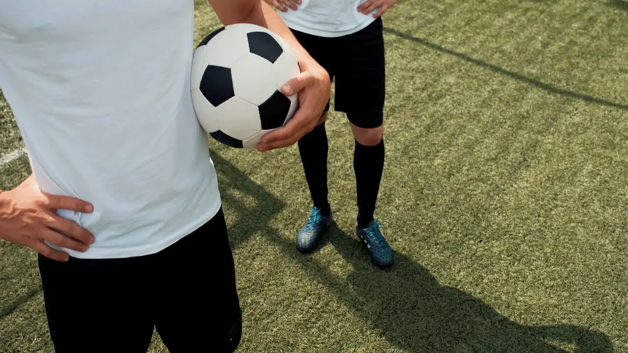 Close Up Of Two Unrecognizable Football Players Standing On A Street Football Pitch