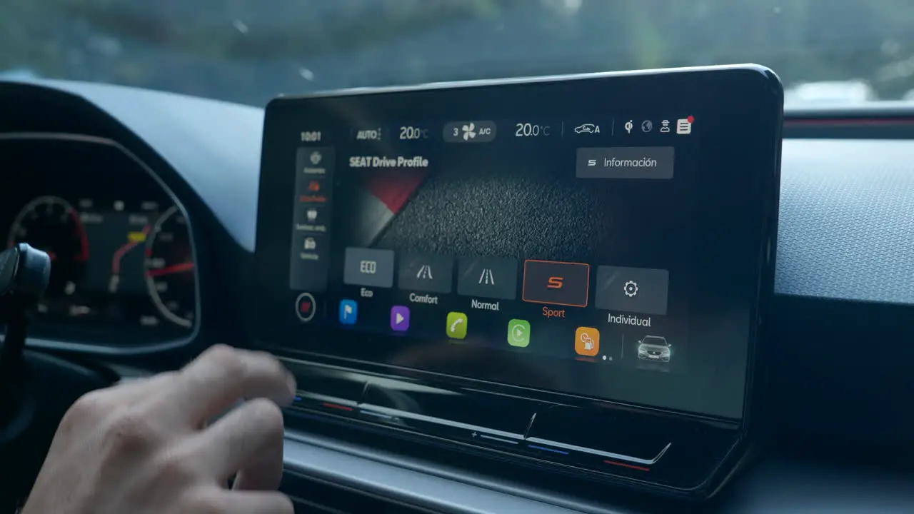 Driver's Hand Shifting From Sport Drive To Eco Drive Mode On The Car Screen