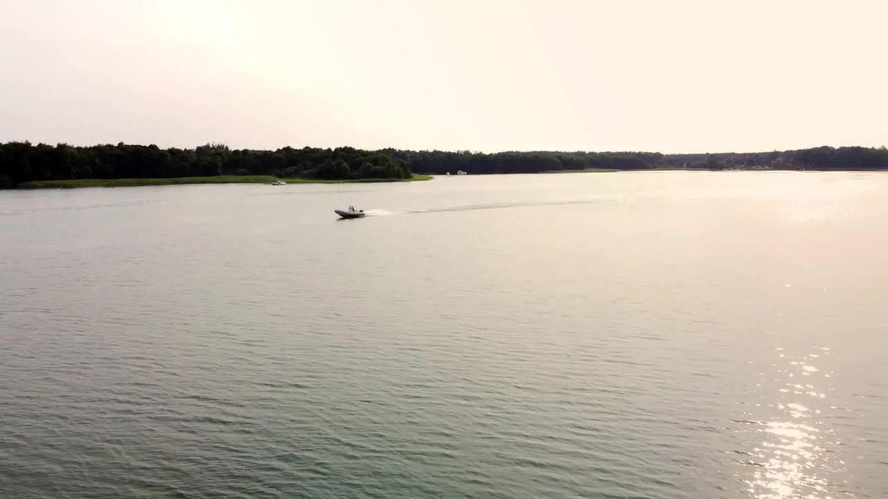 Motor boat driving on a lake during sunset in Brandenburg Germany