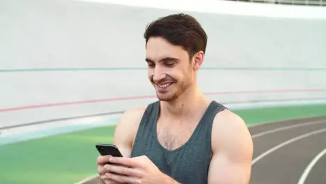 Portrait of jogger with phone on track Closeup runner with phone on stadium