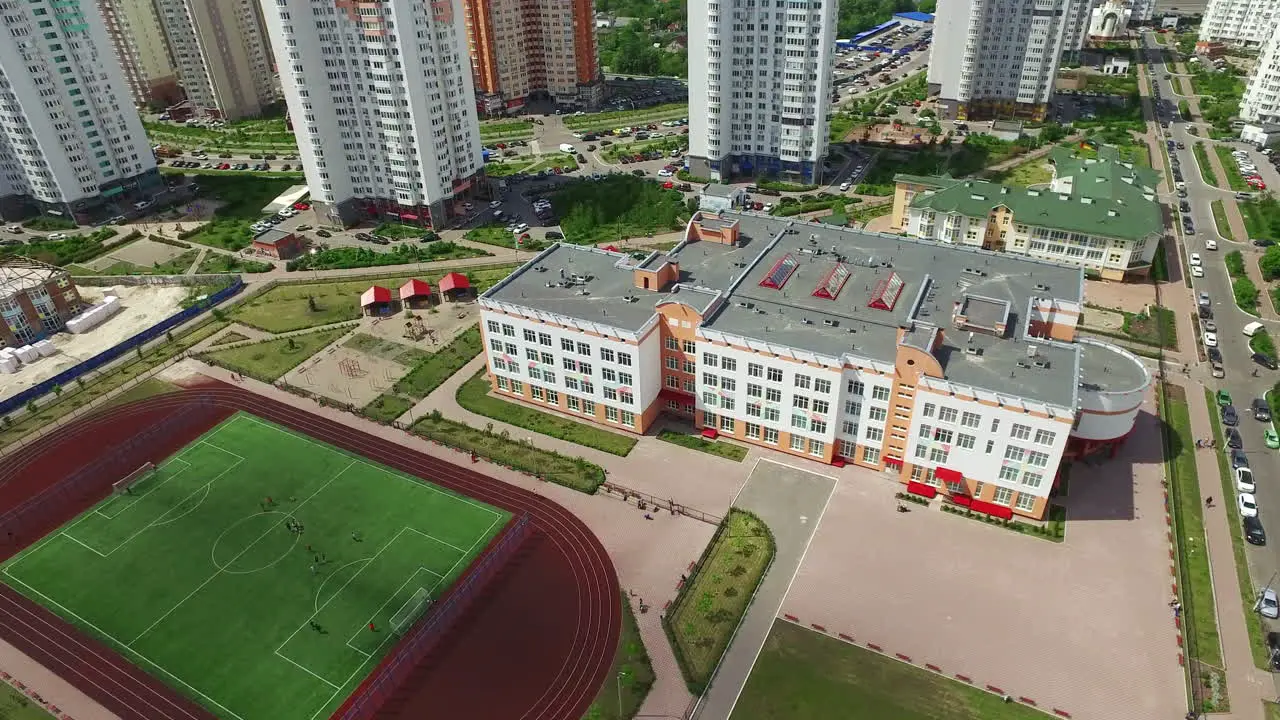 Sports stadium in schoolyard on high rise buildings Aerial view football field