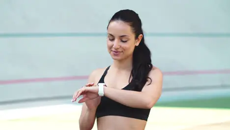 Portrait of female runner using smart watch at stadium