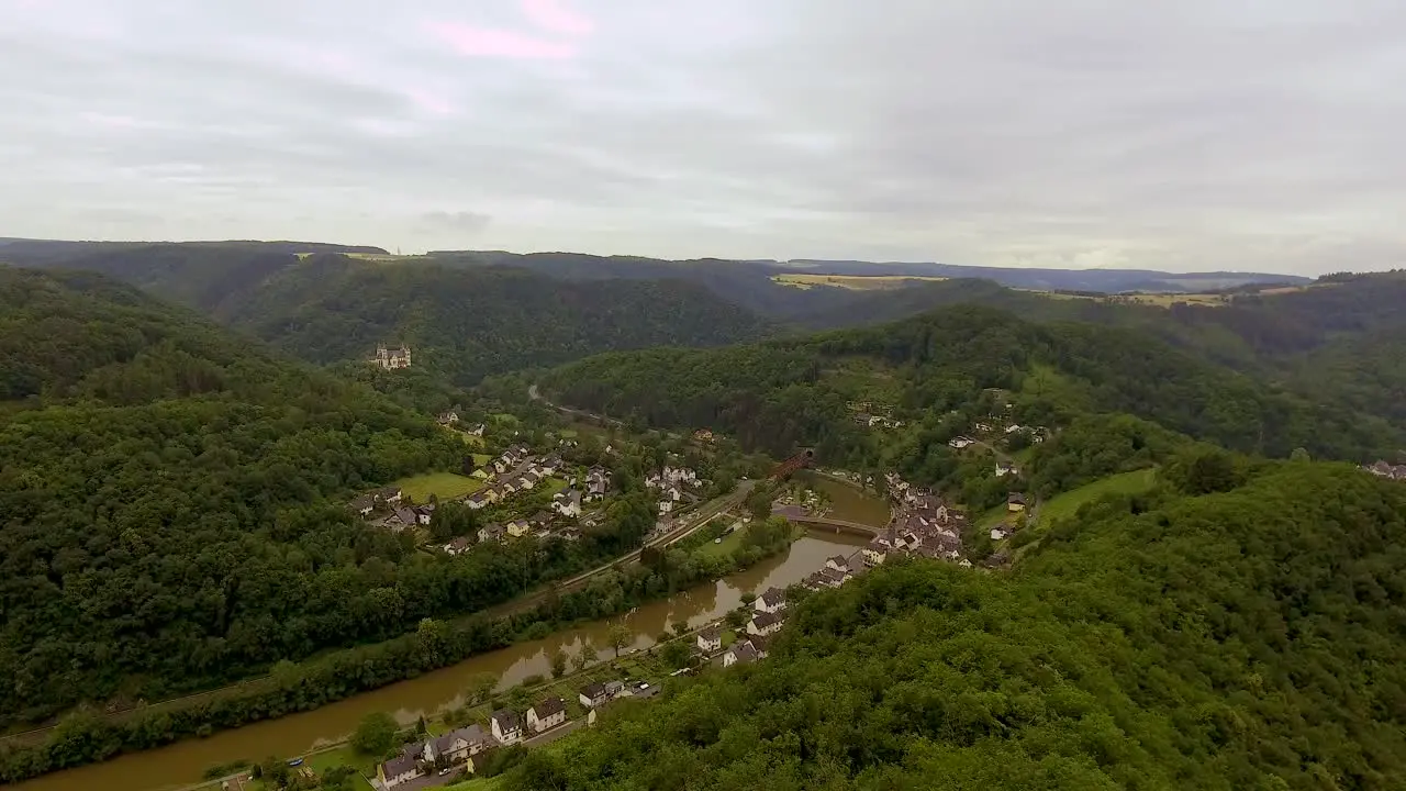 Drone Overview of a German Village at a river with forest and hills surrounding