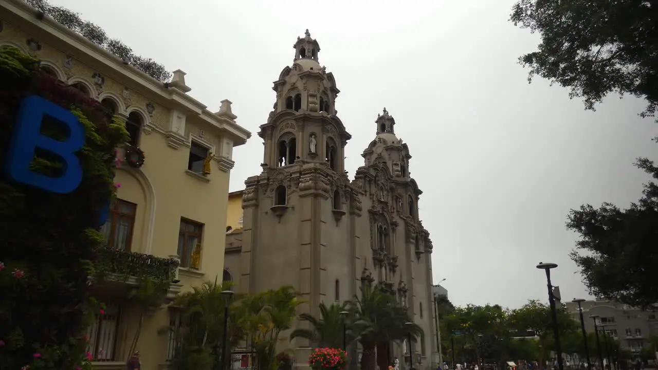 A tall church or cathedral called "Virgen Milagrosa" located in Lima Peru in the Miraflores district very near to a public park called "Parque Kennedy"