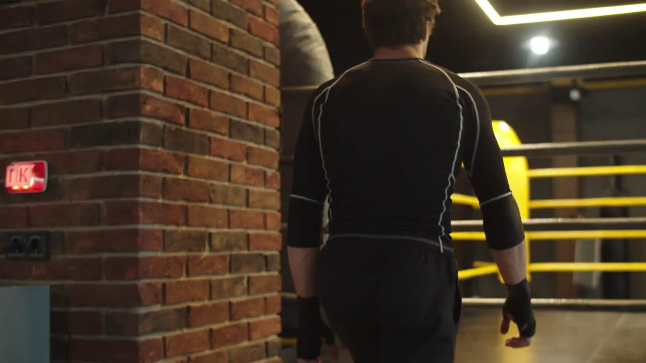 Strong fit man walking up stairs at gym Boxer getting ready for fight in club