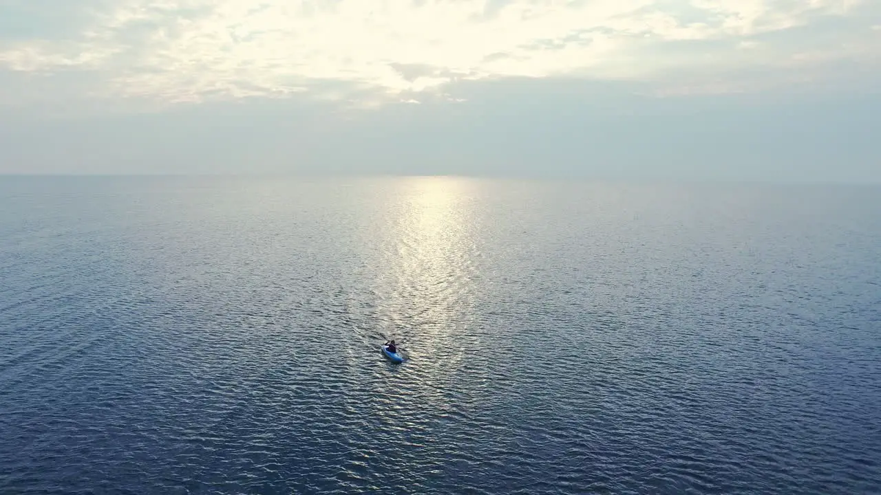 Sportsman swimming kayak in sea at sunset Aerial view kayaker riding in sea