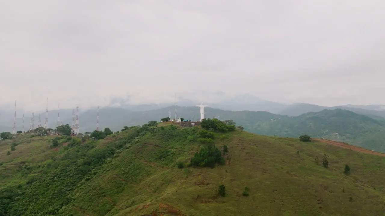 Super fast aerial wide to close footage of the Cristo Rey Jesus statue on top of a mountain outside of Cali Colombia