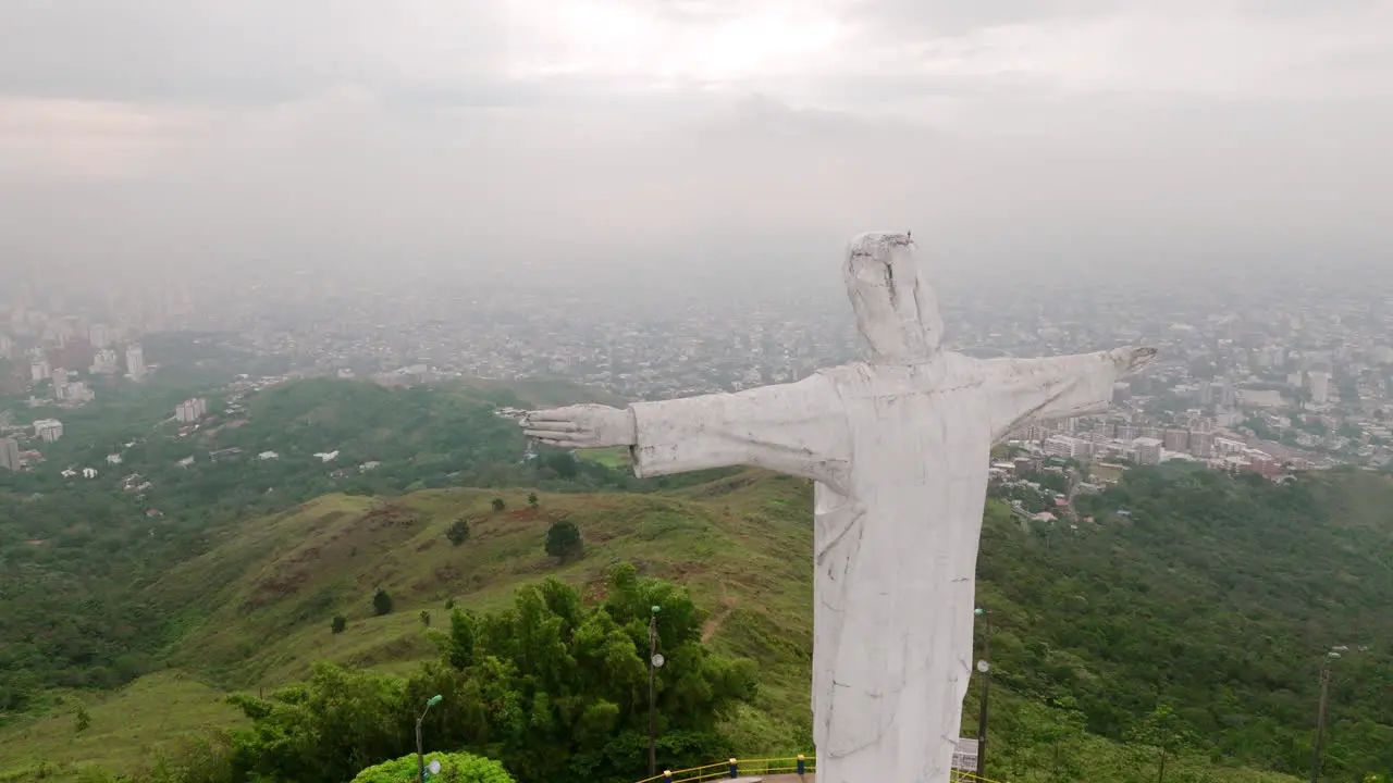 Slow rotating aerial footage of the Cristo Rey Jesus statue on top of a mountain with radio towers all around outside of Cali Colombia