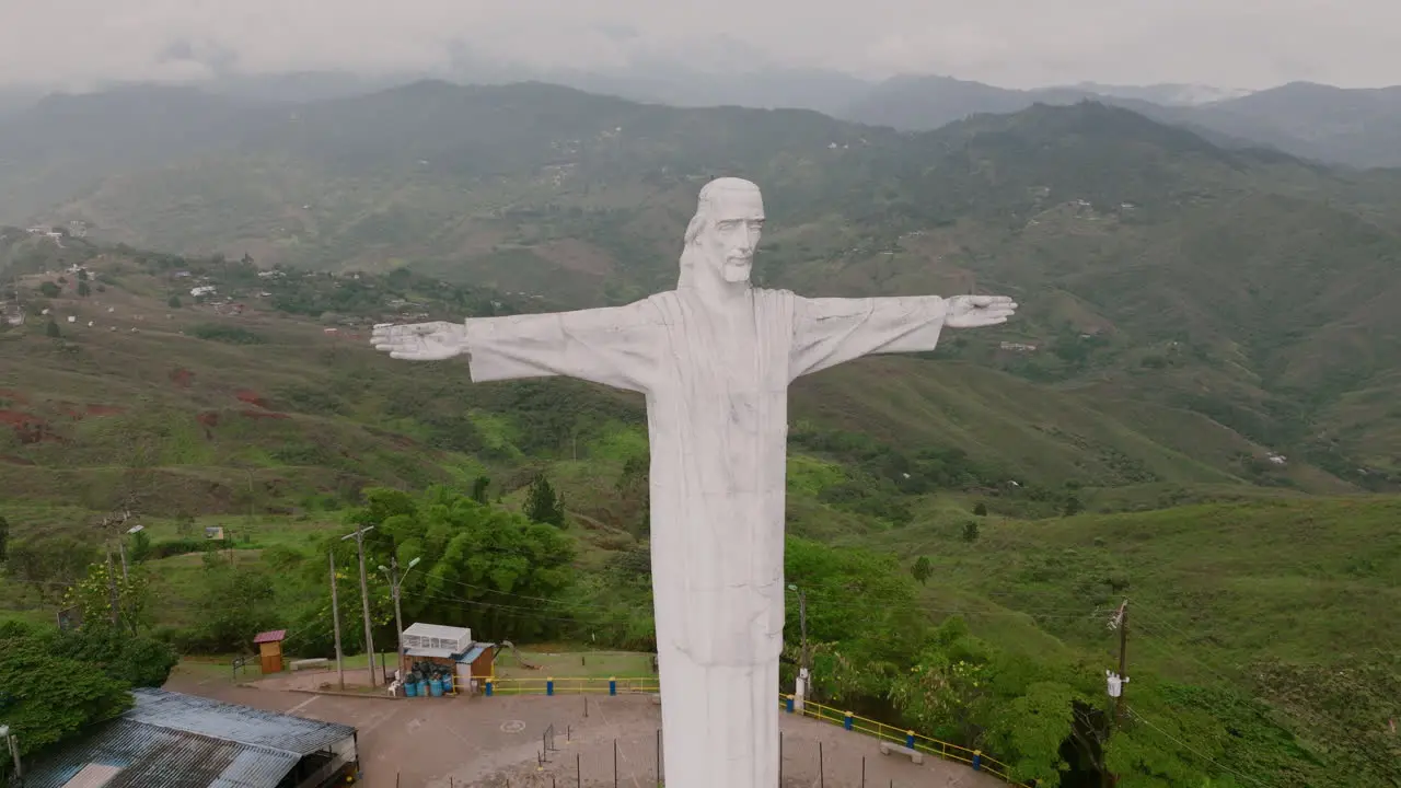 Slow aerial footage at the front of the Cristo Rey Jesus statue on top of a mountain outside of Cali Colombia