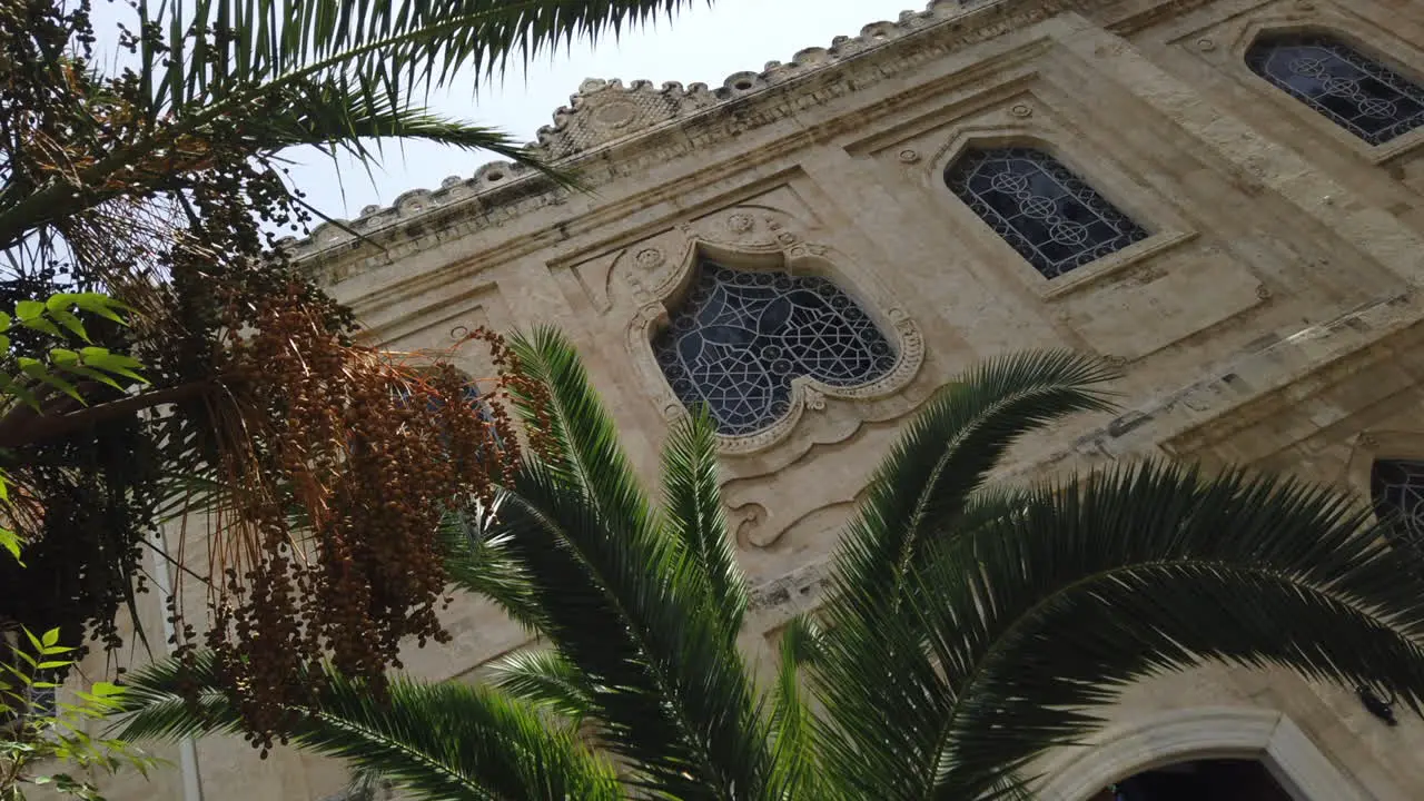 Artistic framing of the Byzantine church of Agios Titos surrounded by palm trees