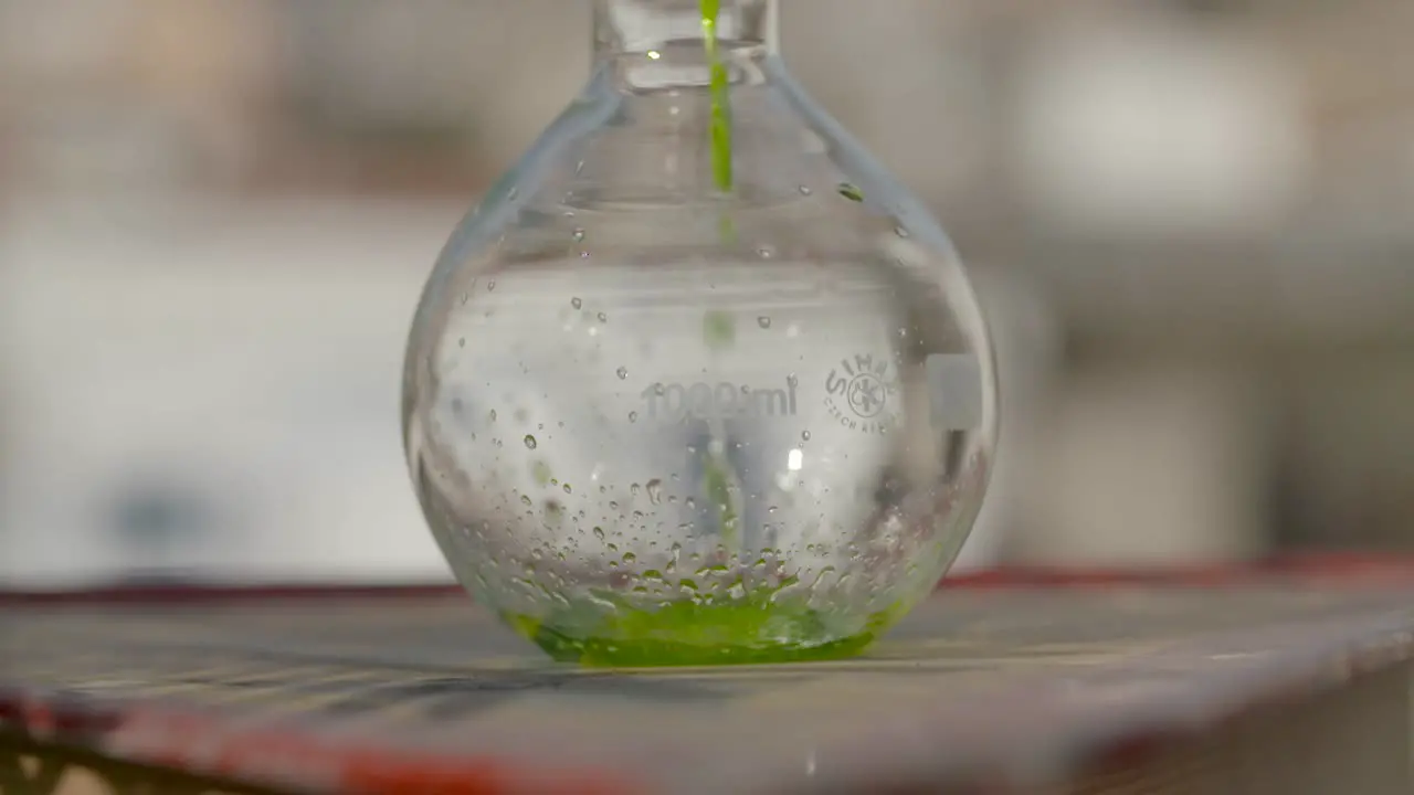 Filling Florence Flask With Green Liquid In Laboratory