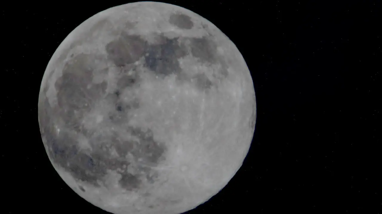 Macro close up of moving bright full moon against dark sky at night time lapse of cosmos moonlight