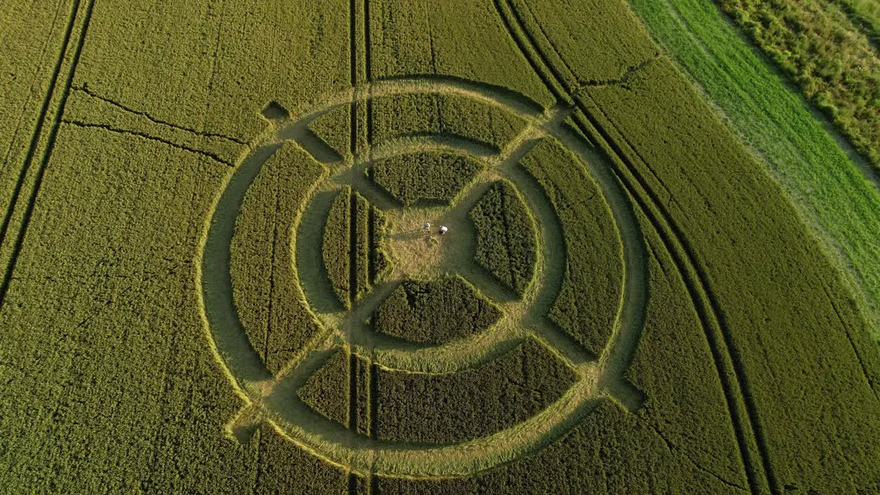 Hackpen hill strange crop circle pattern in rural grass farming meadow aerial view birdseye pull back shot