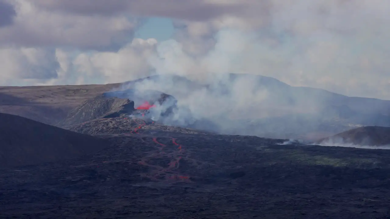 Helicopter flying around spewing Volcano after Eruption observing rocky area in Iceland