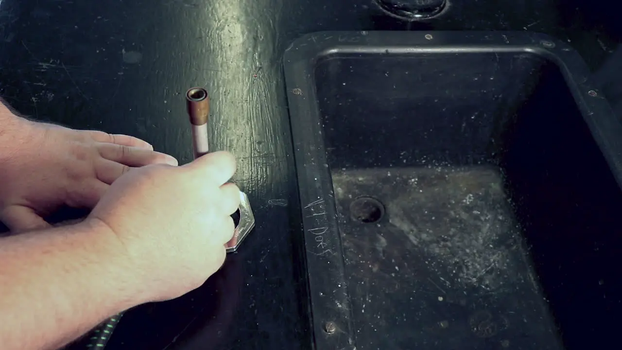 Adjusting the air intake tube on a bunsen burner on a high school chemistry lab bench